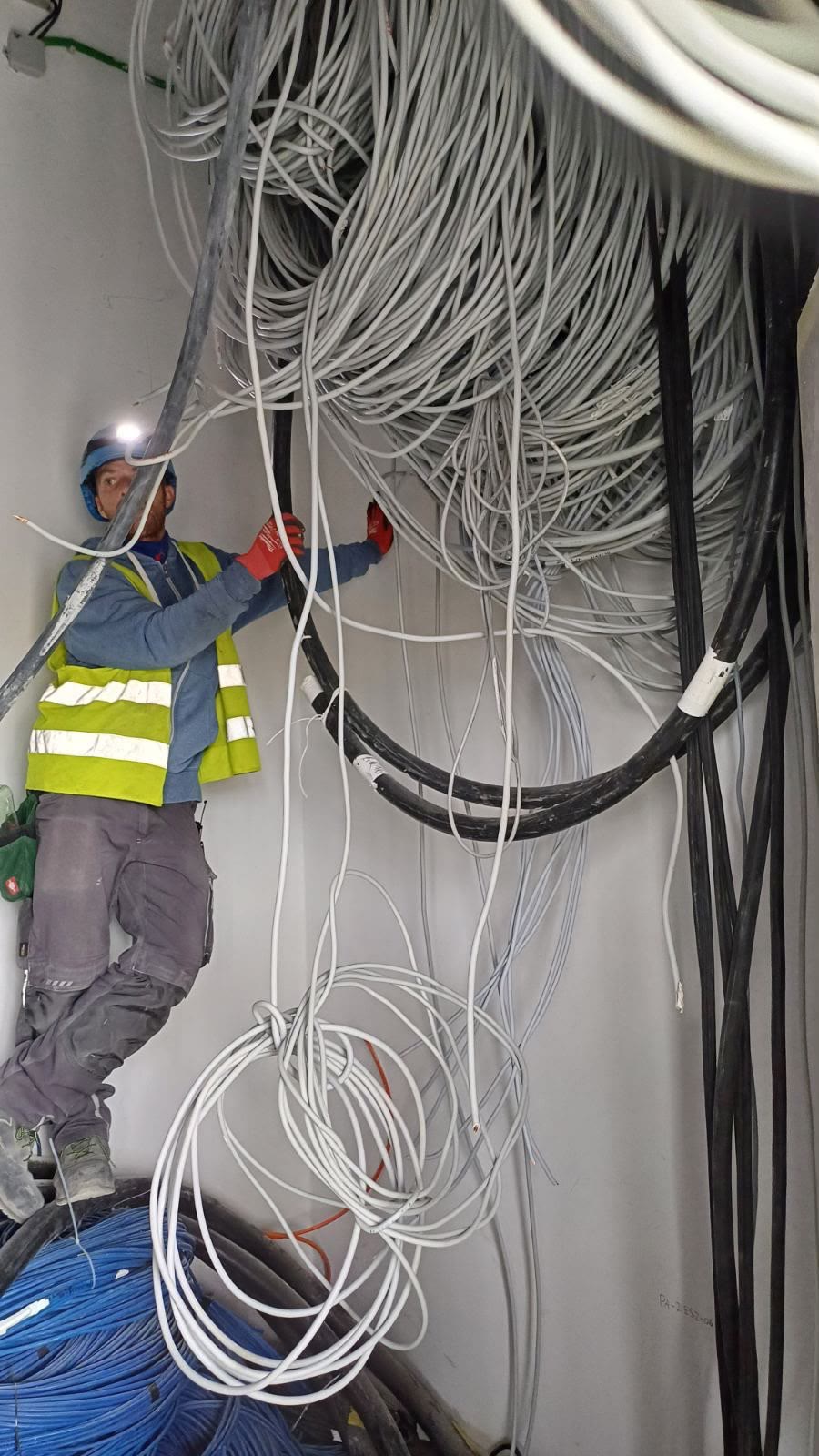 Elektromonteur montiert Kabeltrasse auf der Baustelle