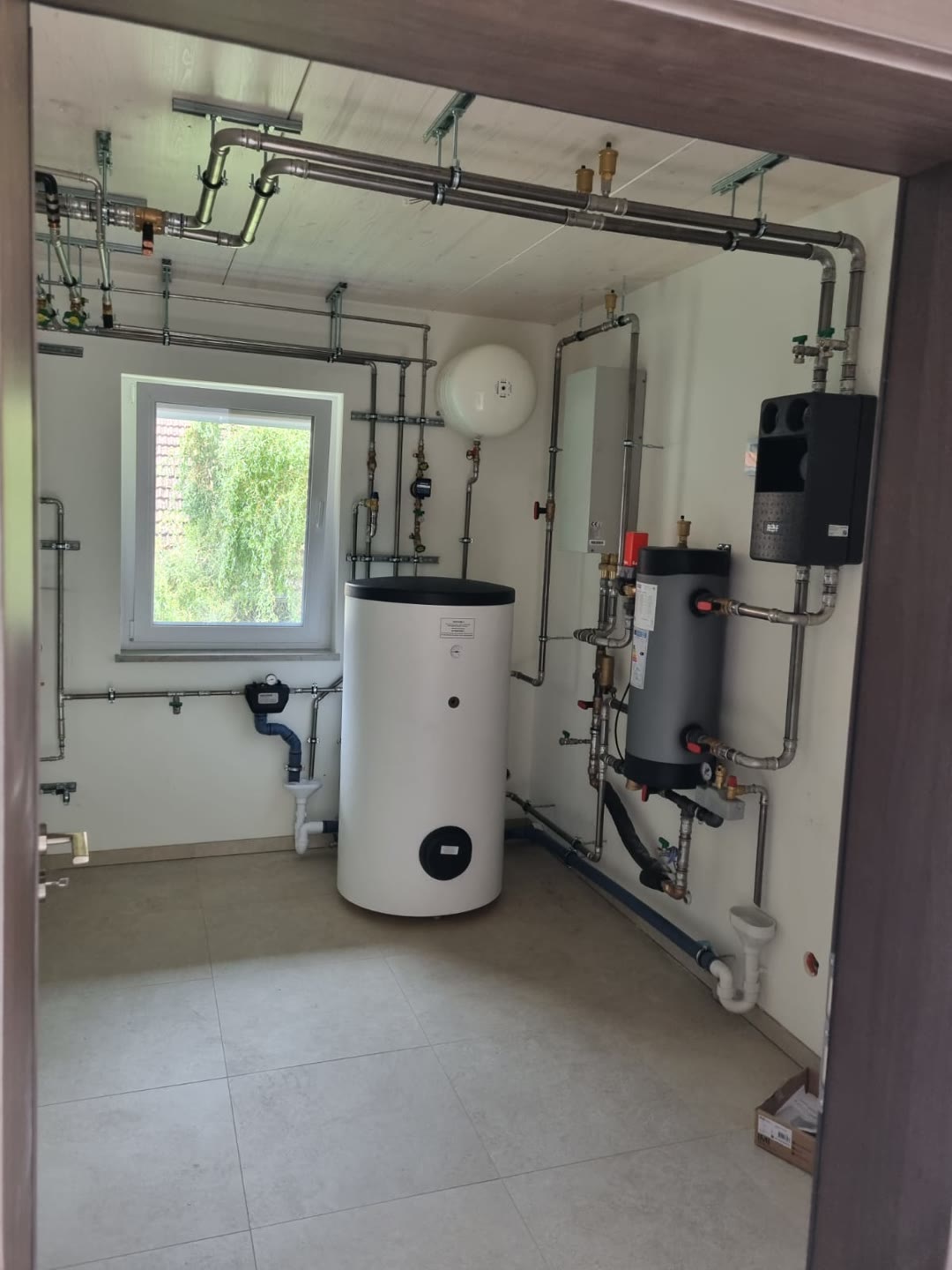 Fertiger Technikraum mit Warmwasserspeicher und Wärmepumpen-Anbindung